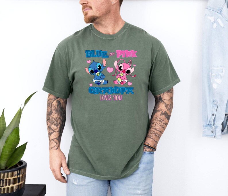 Puede incluir: Una camiseta verde con un gr&aacute;fico de personaje Stitch azul y rosa. El texto en la camiseta dice "Blue or Pink Grandpa Loves You".