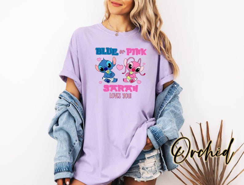 Puede incluir: Una camiseta de color lavanda con un gr&aacute;fico de personaje Stitch azul y rosa. El texto "Blue or Pink Sarah Loves You" est&aacute; impreso en la camiseta.
