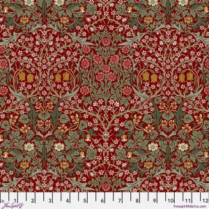 May include: A fabric swatch featuring a dense botanical pattern with deep red background, sage green leaves, and small white, pink, and gold flowers. A white ruler at the bottom shows measurements from 0 to 12 inches, labeled FreeSpirit.