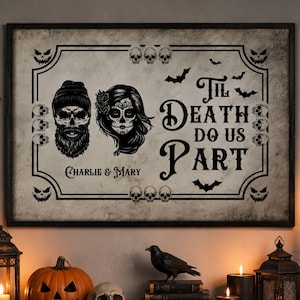 Op de afbeelding: Een rechthoekige ingelijste wanddecoratie met een verweerde gebroken witte achtergrond en zwarte illustraties van een schedel met baard en een suikerschedel. De tekst 'Til Death Do Us Part' en 'Charlie & Mary' wordt omringd door schedel- en vleermuispatronen.