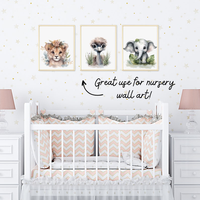 May include: Three watercolor animal prints featuring a lion, ostrich, and elephant. The prints are framed and hung on a white wall with gold stars. The prints are a great addition to a nursery.
