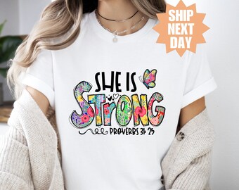 May include: White t-shirt with a colorful floral design that says "She is Strong" and "Proverbs 31:25".