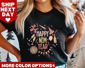 May include: Black t-shirt with a pink and gold graphic design that says "Happy New Year". The design includes party hats, balloons, champagne glasses, and a disco ball.