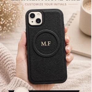 May include: Black leather phone case with the initials "M.F" in gold. The case has a textured surface and is designed to be personalized. The text "PERSONALIZED LEATHER PHONE CASE" is displayed at the top.