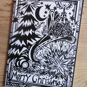 Peut inclure: Carte de Noël en noir et blanc avec une illustration détaillée. Le dessin comprend un croissant de lune, des étoiles, un sapin de Noël stylisé et les mots "Merry Christmas". La carte a une bordure décorative.