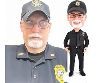 May include: A custom bobblehead figurine depicting a corrections officer wearing a black uniform, a matching cap with a badge, and glasses. The figure has a white goatee and is standing on a circular white base, mirroring the appearance of the person.