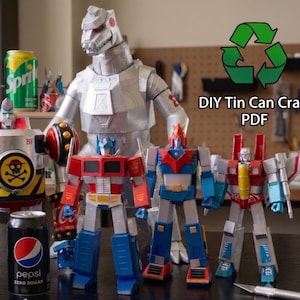 Puede incluir: Una colección de figuras de robots hechas con latas de refresco de aluminio, que incluye una gran criatura mecánica plateada, un robot inspirado en un camión rojo y azul, y otras dos figuras humanoides multicolores, con el texto DIY Tin Can Craft PDF.