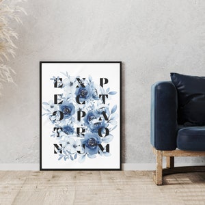 May include: A black framed print with a white background and blue watercolor flowers. The flowers are arranged in a grid pattern with the letters "EXPECT THE UNEXPECTED" spelled out in black.