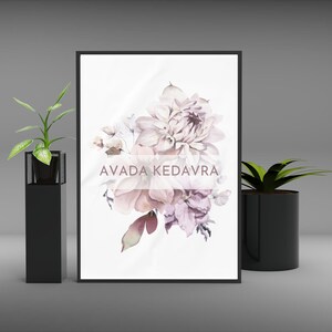 May include: A framed print with a watercolor painting of a bouquet of pink and purple flowers. The text "AVADA KEDAVRA" is printed in pink on the print.