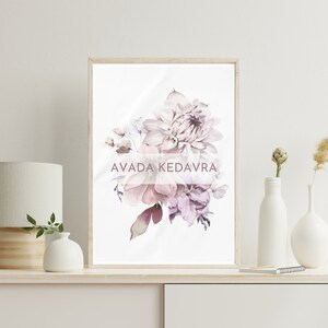 May include: A framed print of a watercolor painting of a bouquet of pink and purple flowers. The text "AVADA KEDAVRA" is printed in a pink font on the print.