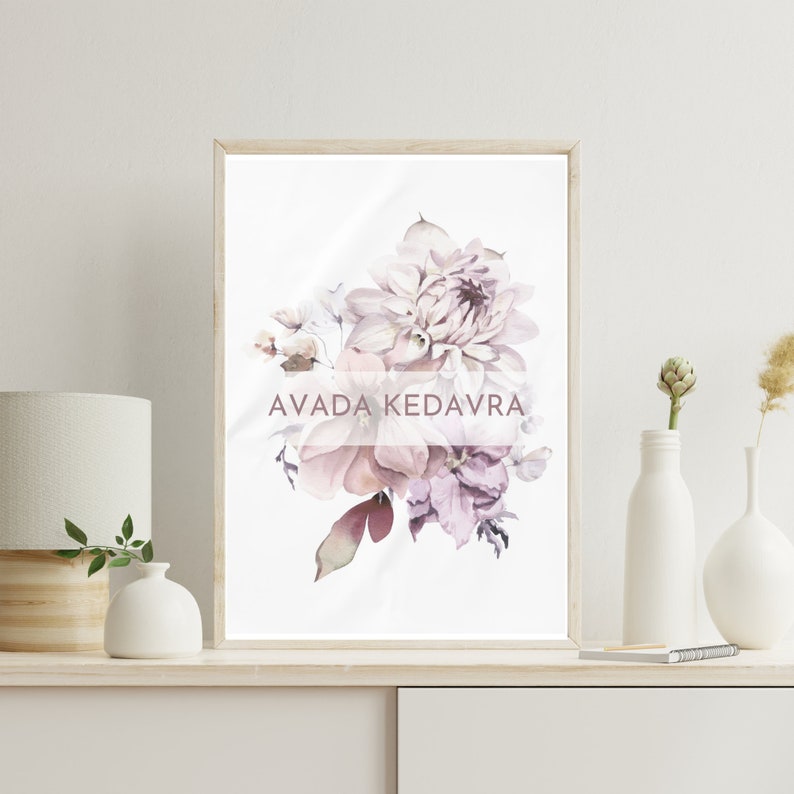 May include: A framed print of a watercolor painting of a bouquet of pink and purple flowers. The text "AVADA KEDAVRA" is printed in a pink font on the print.