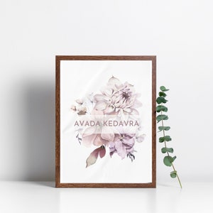 May include: A framed print with a watercolor painting of a bouquet of pink and purple flowers. The text "AVADA KEDAVRA" is printed in a light pink font on the print.