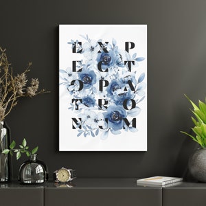 May include: A white canvas print with blue watercolor flowers and the word "EXPECT THE UNEXPECTED" spelled out in black letters.