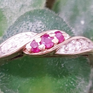 May include: A gold ring with a twisted band set with small diamonds and five pink rubies.