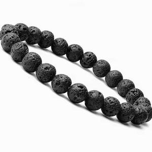 May include: Two strands of black lava rock beads. The beads are round and have a porous texture. The beads are strung together to form bracelets or necklaces. The background is white.