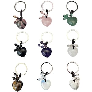 May include: Nine heart-shaped gemstone keyrings in various colours, including pink, green, black, purple, white, and brown. Each keyring features a silver ring and a decorative beaded accent.