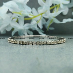 K&ouml;nnte beinhalten: Ein zartes Silberarmband mit einer Reihe kleiner, quadratischer Diamanten. Das Armband ist schlicht und elegant und perfekt f&uuml;r den Alltag.