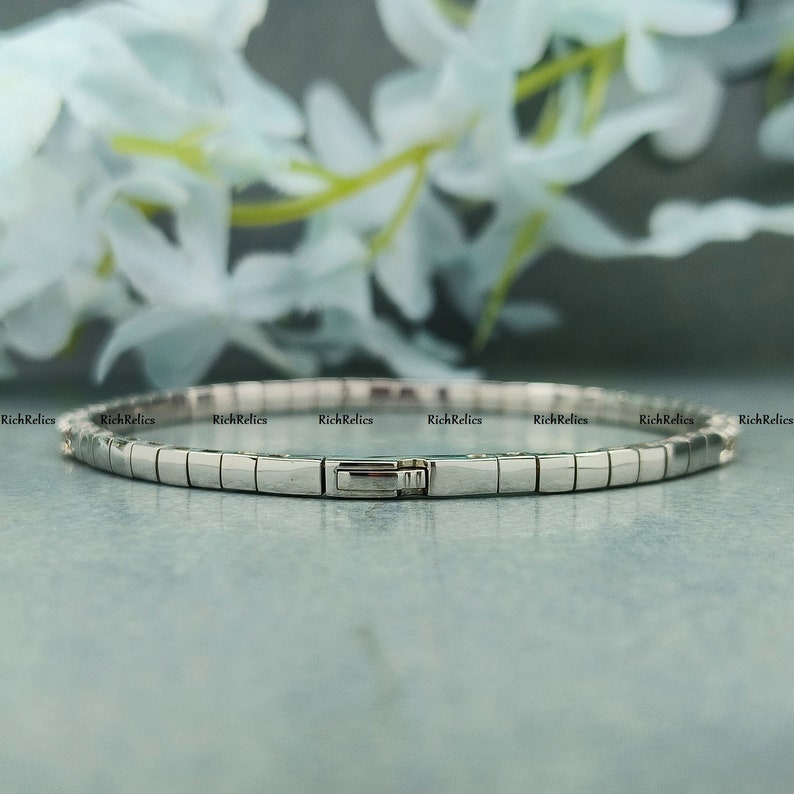K&ouml;nnte beinhalten: Ein silbernes Armband mit einem Verschluss. Das Armband besteht aus kleinen, rechteckigen Gliedern.