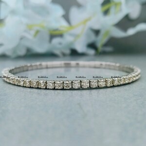 K&ouml;nnte beinhalten: Ein silbernes Tennisarmband mit einer Reihe kleiner, runder Diamanten.