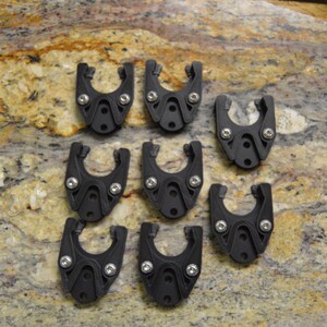 May include: Ten black plastic clips with silver screws. The clips are designed to hold items in place.