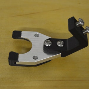 May include: A black and silver metal bike mount with two screws. The mount has a rubberized grip on the bottom.
