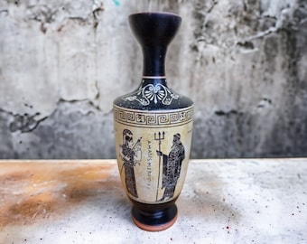 May include: A black and white ceramic vase with a Greek design featuring two figures and the text "AMASIS ME NEKOISI".