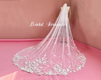 May include: A white bridal veil with delicate floral embroidery. The veil is made of soft tulle and features a scalloped edge.