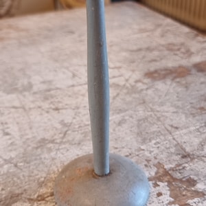 May include: A light gray wooden hat stand with a round top and a circular base.