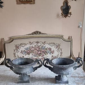 Hermoso juego de dos jardineras tipo urna Medicis de hierro fundido con acabado gris mate y asas en los laterales.
