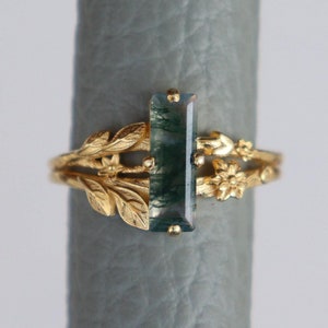 Op de afbeelding: Gouden ring met een groene agaat-steen gezet in een bladmotief.