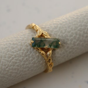 May include: Gold ring featuring a green agate stone set within a leafy design.