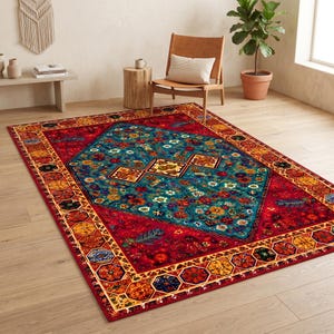 May include: A rectangular area rug featuring a deep red border with repeating octagonal floral motifs in yellow, orange, and blue. The central field is a large teal diamond shape filled with intricate floral patterns and geometric shapes.