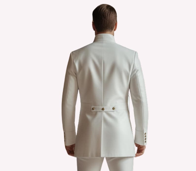 Puede incluir: Chaqueta de traje blanca con cuello mandar&iacute;n y detalles de botones. La chaqueta tiene mangas largas y un corte entallado. La parte trasera de la chaqueta presenta un peque&ntilde;o detalle de cintur&oacute;n con tres botones. El traje es de color blanco liso.