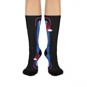May include: A pair of black socks with a blue and red design. The socks feature a geometric pattern with a pink outline.