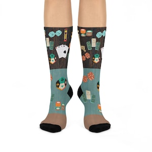 May include: A pair of blue and brown socks with a design of playing cards, dice, dominoes, and poker chips. The socks are made of a soft, comfortable material and are perfect for everyday wear.