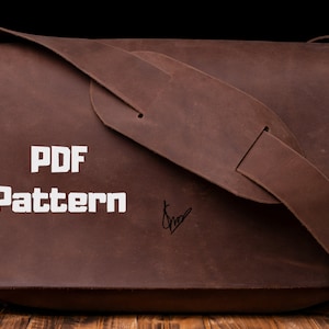 Può includere: Una borsa a tracolla in pelle marrone con una tracolla bianca e il testo "PDF Pattern" stampato sul davanti.