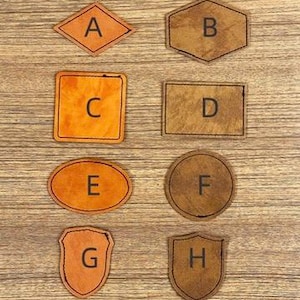 May include: A collection of eight leather patches in various shapes: diamond, hexagon, square, rectangle, oval, circle, shield, and a second shield shape. Each patch features a single letter from A to H.
