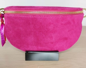Pretty fanny pack in fuchsia suede, zipper opening. strap matching the bag. Matte steel finishes.