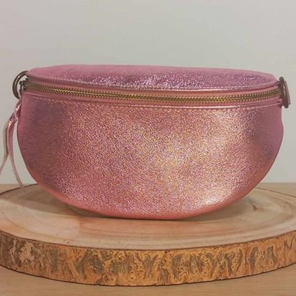 Sac banane en cuir brillant "Leo" de couleur rose pâle et avec sangle assortie. Finitions métalliques en acier brillant.