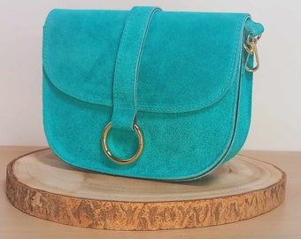 Sac en cuir, daim ou suède, "Andromeda" de couleur turquoise et avec sangle assortie. Finitions métalliques en acier brillant.