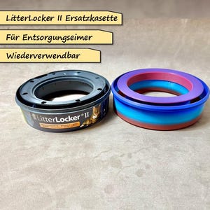 Puede incluir: Dos contenedores de arena para gatos. Uno es gris y tiene el texto "LitterLocker II" en él. El otro es un anillo multicolor con capas azules, moradas y rojas. Ambos contenedores están etiquetados con "LitterLocker II Ersatzkassette" y "Für Entsorgungsseimer" y "Wiederverwendbar".