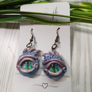 Polymer Clay Dragon&#39;s Eye Earrings. Hand sculpted with painted glass cabochon with antique-gold finish findings.