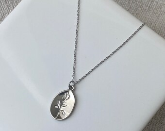 Collier argenté à médaille avec une rose