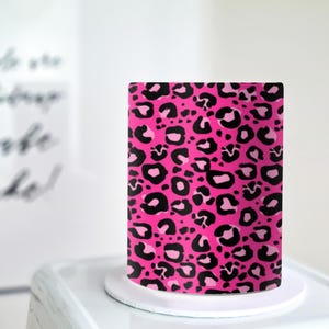May include: A pink cake with a black leopard print design.