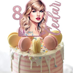 May include: A pink and white striped cake with white frosting and sprinkles. The cake is topped with macarons and a pink glitter cake topper with a picture of a woman and the text "8 Cedar".