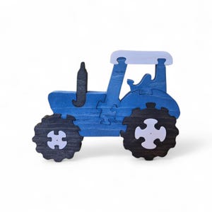 May include: A blue wooden tractor puzzle with black and white wheels and a white roof. The toy tractor is made of interlocking pieces and is designed for children. The puzzle is a fun and educational toy for kids.