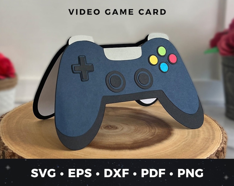 May include: A blue and black video game controller card with colorful buttons. The card is on a wooden surface. SVG, EPS, DXF, PDF, PNG.