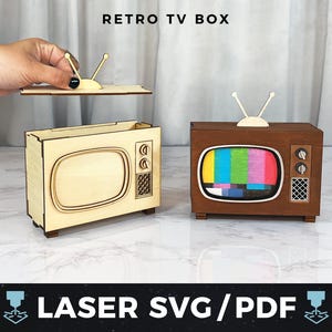 以下が含まれることがあります： 木製のレトロテレビボックスが2つ。1つは組み立て済み、もう1つは部分的に組み立てられています。組み立てられたテレビは茶色で、カラフルな画面とアンテナが付いています。もう1つは明るい色の木材です。「RETRO TV BOX」の文字が上部にあります。