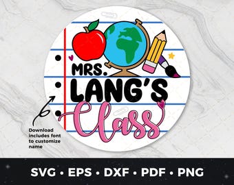 Puede incluir: Un círculo redondo, blanco y azul con una manzana roja, un globo terráqueo, un lápiz y un pincel. El texto "MRS. LANG'S Class" está escrito en letras negras y rosas.