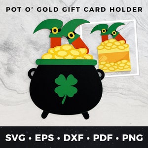 May include: A black pot of gold with a shamrock and two leprechauns holding gold coins. The pot of gold is a gift card holder.  Pot O' Gold Gift Card Holder.